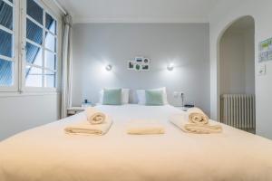 een slaapkamer met een groot wit bed en handdoeken bij Relais du Bas Limousin in Sadroc