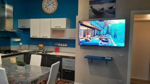 a kitchen with a tv hanging on a wall at CASA MARIA1 in Cigole