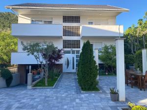 a white house with a patio in front of it at Guest House NO 13 in Mostar