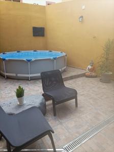a large tub sitting next to a man sitting on the floor at Tradicional Casa Canaria con piscina y vistas al Teide in Icod de los Vinos