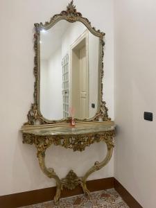 un espejo de oro ornamentado en una pared de una habitación en B&B Albergo Centrale Gioiosa Ionica, en Gioiosa Ionica