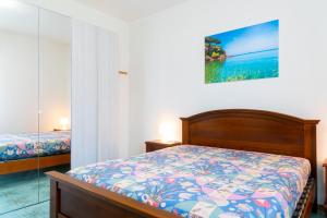 Un dormitorio con una cama y un cuadro en la pared. en Appartamento Terrazza, en Portoferraio