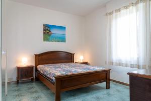 1 dormitorio con 1 cama y una ventana con 2 lámparas en Appartamento Terrazza, en Portoferraio