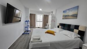 a bedroom with a bed with a yellow towel on it at Serenity Sea View Apartment in Olimp