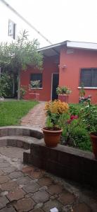 een huis met twee potten bloemen ervoor bij Country House in Los Planes. in Panchimalco