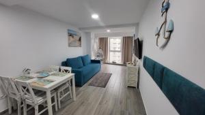 a living room with a blue couch and a table at Serenity Sea View Apartment in Olimp