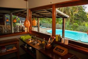 a kitchen with a swimming pool seen through windows at Mística Pipa Hostel in Pipa +22 photos