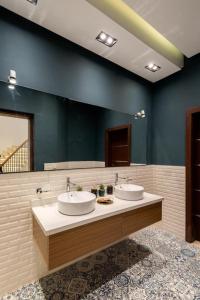 a bathroom with two sinks and a large mirror at Settle Inn Luxury Swan Lake Villa in Cairo