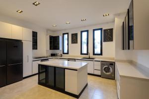 a large kitchen with white cabinets and a sink at Settle Inn Luxury Swan Lake Villa in Cairo