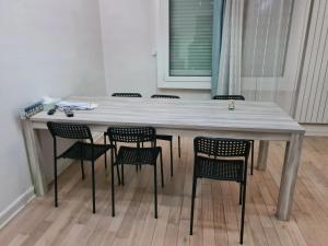 a table with chairs around it with a table and a window at Maison de 3 chambres avec jardin clos et wifi a Merignac in Mérignac