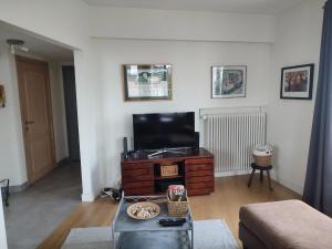 a living room with a television and a table at One bedroom apartement with balcony and wifi at Etterbeek in Brussels