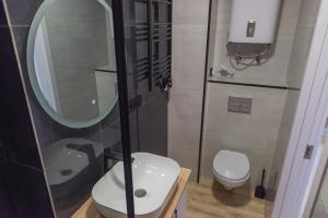 ein Badezimmer mit einem WC, einem Waschbecken und einem Spiegel in der Unterkunft Lux Apartments G62 in Tbilisi City