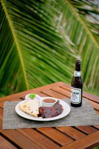 einen Tisch mit einem Teller Essen und einer Flasche Bier in der Unterkunft Casa Al Mar, St. George's Caye - Belize in Belize City