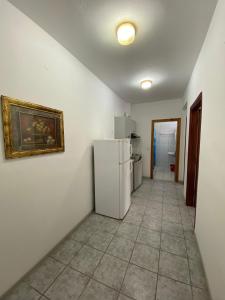 a kitchen with a refrigerator and a painting on the wall at Villa Ilias in Olympiaki Akti