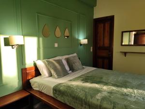 a bedroom with a bed with green walls at Electra's Seaside in Agios Georgios