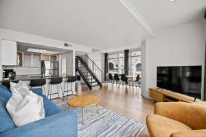 奥斯汀Littlefield Lofts, Hosted by Placemakr - 6th St的带蓝色沙发的客厅和厨房