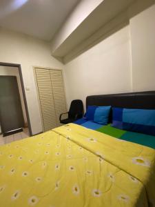 um quarto com uma cama amarela e uma cadeira em PD Seaview Paradise Lagoon Apartment em Porto Dickson