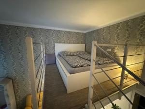 ブダペストにあるSilverlight Luxus Downtownのベッドと階段が備わる小さな客室です。