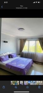 1 dormitorio con cama morada y ventana en Masaki Anne H & Apartment, en Dar es Salaam