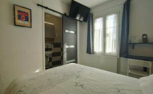 a bedroom with a bed and a bathroom with a window at Hôtel Saint Jean in Tours