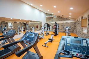 a gym with treadmills and elliptical machines at Hotel Puente de Alconétar in Garrovillas