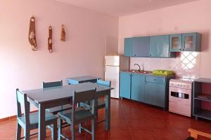 a kitchen with blue cabinets and a table and chairs at Appartamento Ferreira Stella Maris Exclusive in Calheta Do Maio