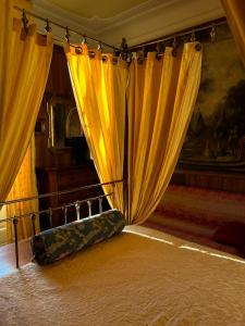 Habitación con cortinas amarillas y cama con alfombra. en Villa Puccini, en Venegono Superiore