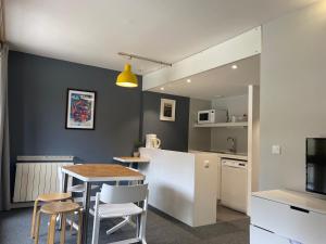 kuchnia i jadalnia ze stołem i krzesłami w obiekcie Studio calme rénové, balcon, Wifi, parking inclus, proche Transarc et commerces - FR-1-346-345 w mieście Arc 1800