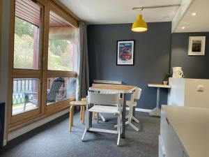 kuchnia ze stołem i krzesłami oraz oknem w obiekcie Studio calme rénové, balcon, Wifi, parking inclus, proche Transarc et commerces - FR-1-346-345 w mieście Arc 1800