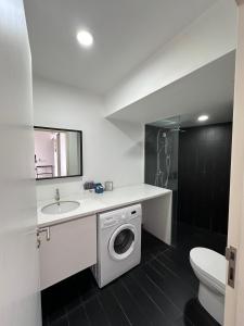 Un baño con lavadora y lavabo. en Homoto Petaling Jaya, en Petaling Jaya 45 fotos más