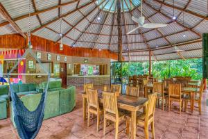 a restaurant with wooden tables and chairs and a couch at Osa Conservation Campus in Cabo Matapalo