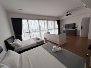 Una habitación de hotel con dos camas y una gran ventana. en Homoto Petaling Jaya, en Petaling Jaya
