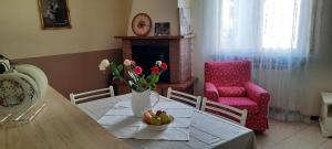 uma sala de jantar com uma mesa com flores e uma cadeira em Ildi's Guest House em Seriate