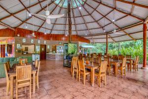 a restaurant with wooden tables and chairs and a ceiling at Osa Conservation Campus in Cabo Matapalo