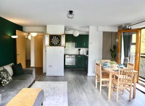 a living room with a couch and a table and a kitchen at Modern Spacious Apartment in Thornton Heath