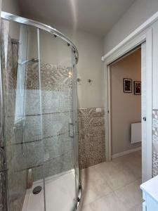 een douche met een glazen deur in de badkamer bij B&B DaBi in Alghero