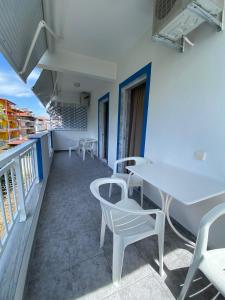 a balcony with tables and chairs on a building at Villa Ilias in Olympiaki Akti