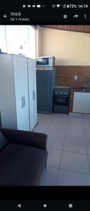 um quarto com uma cozinha com fogão e armários em Cantinho do sossego em Salvador