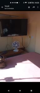 Cantinho do sossego في سلفادور: غرفة مع تلفزيون ومروحة على طاولة
