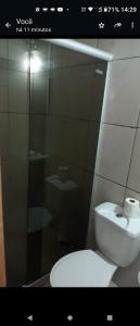 uma casa de banho com um WC e uma cabina de duche em vidro. em Cantinho do sossego em Salvador