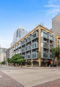 a large building on a city street with tall buildings at Littlefield Lofts, Hosted by Placemakr in Austin