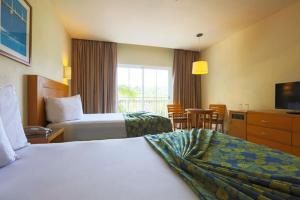 a hotel room with two beds and a television at Krystal Vallarta in Puerto Vallarta