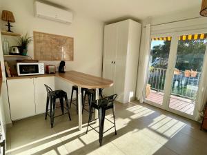 cocina con mesa y sillas en una habitación en Appartement cosy vue mer à 50 m de la plage - refait à neuf et climatisé, en Le Pradet