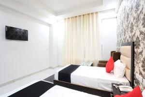 a hotel room with a bed and a tv at OYO Hotel Aroma Regency in Meerut