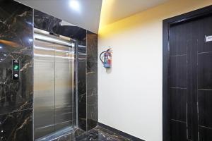 a shower in a bathroom with a door at OYO Hotel Aroma Regency in Meerut