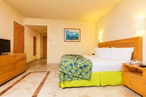 une chambre d'hôtel avec un lit et une télévision dans l'établissement Krystal Vallarta, à Puerto Vallarta