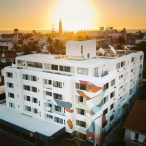 埃斯特角城的住宿－ZAG Coliving Punta del este，一座白色的大建筑,上面有绘画作品