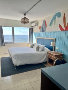 a bedroom with a large bed with a blue wall at ZAG Coliving Punta del este in Punta del Este