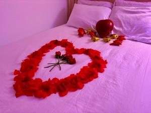 a heart made out of red roses on a bed at Condado Lux Oceanfront Tantra Ap in San Juan