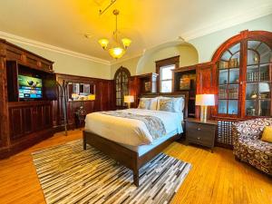 1 dormitorio con 1 cama y 1 silla en The Eden Hall Inn, en Charlottetown